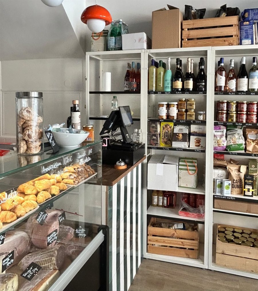 L'intérieur de NOVAROSA : la vitrine des pâtisseries et de la charcuterie, et les étagères de vins et de produits italiens