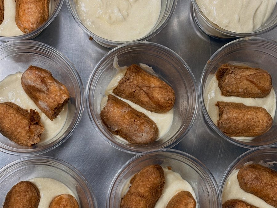 Tiramisu maison en préparation : biscuits imbibés et crème, dans des coupes individuelles